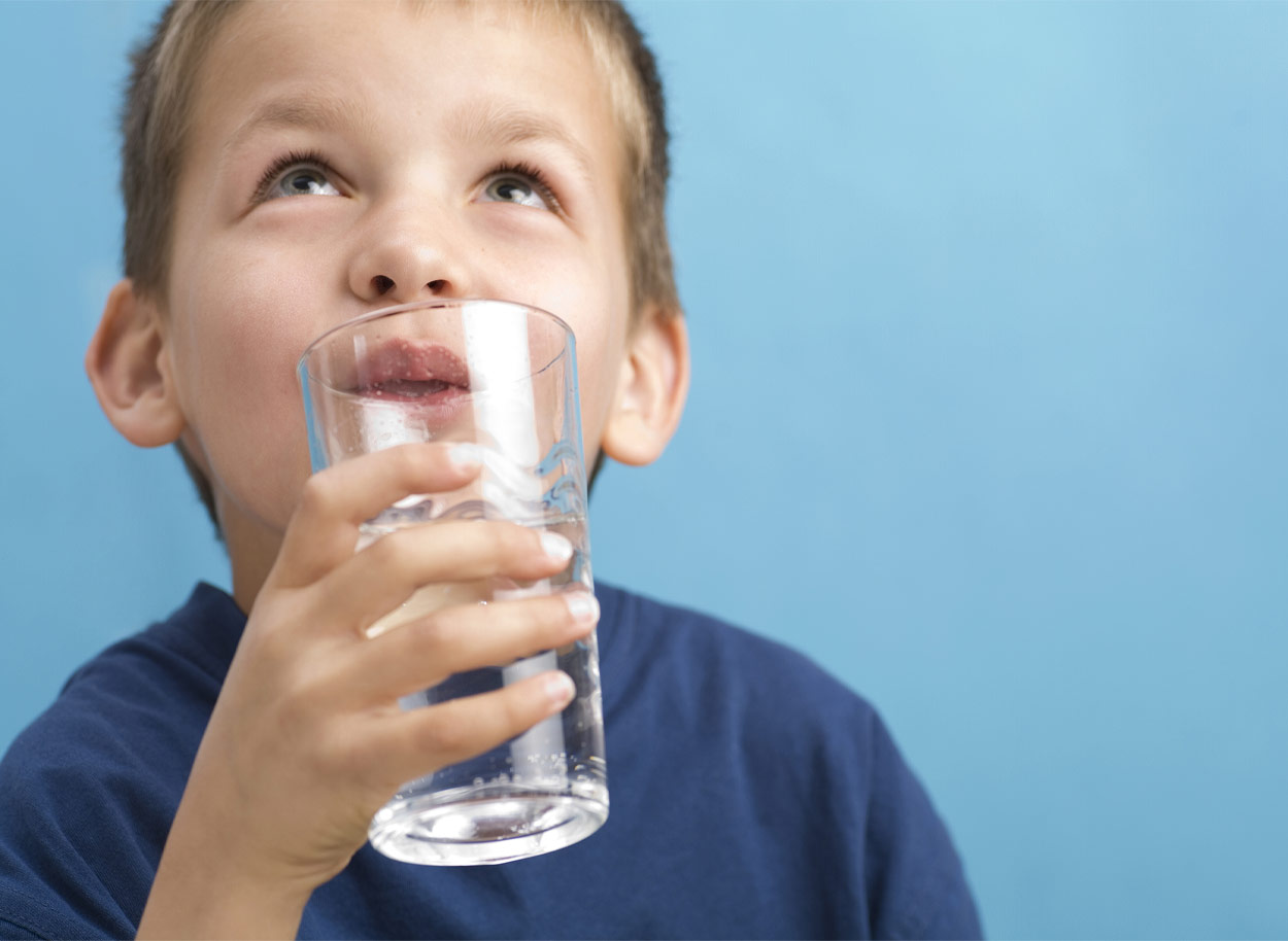 Un enfant buvant un verre d'eau