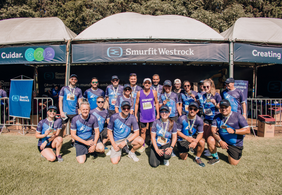 Colaboradores da Smurfit Westrock reunidos após corrida em evento esportivo, em frente ao estande da empresa durante a Maratona do Vinho.